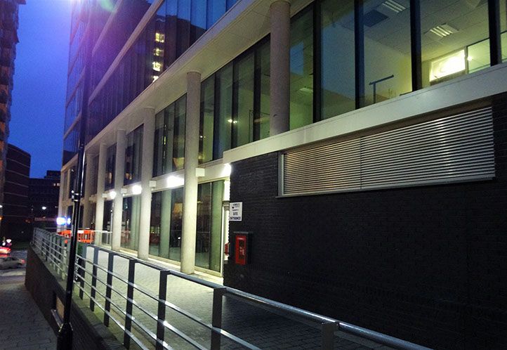 A photo of the outside of a building at night time with the outside lights on