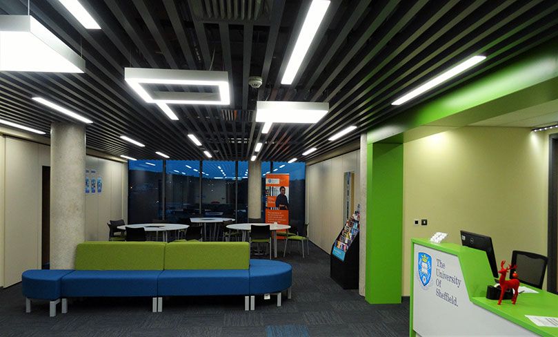 A photo of the reception area to a University of Sheffield building with the lights on