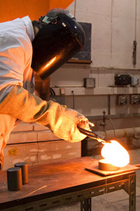 A photo of a man glass sculpting with molten glass