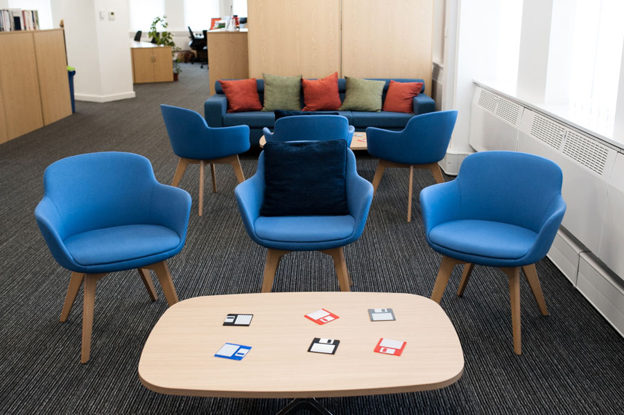 A photo of a chill out area in an office with blue chairs