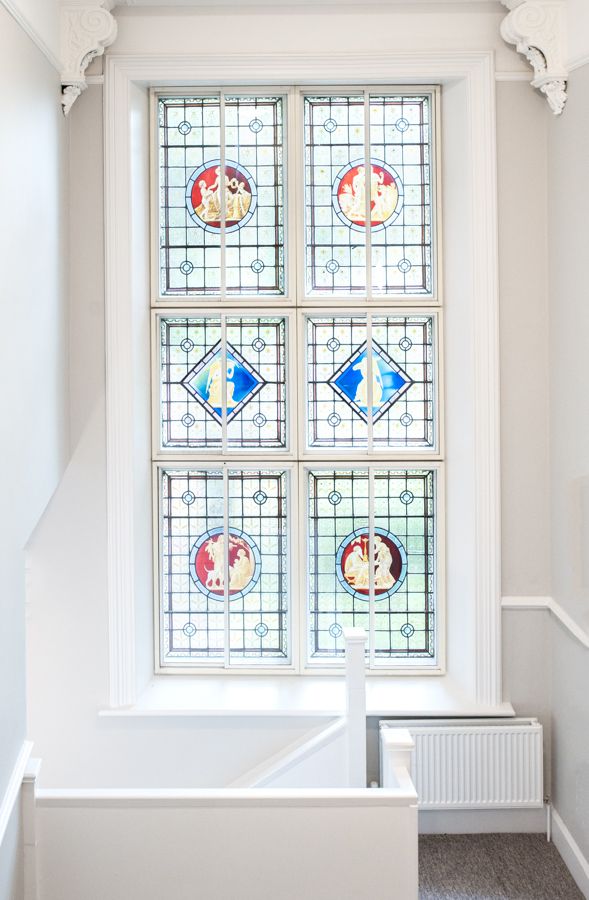 A photo of a stained glass window at the top of some stairs